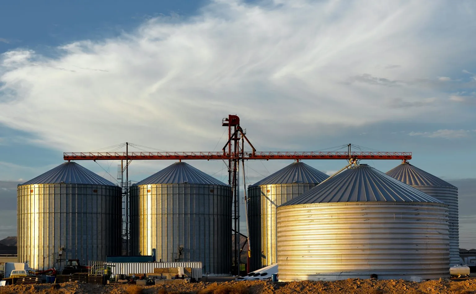 Cinco silos metálicos de grano con la pasarela de carga entre ellos