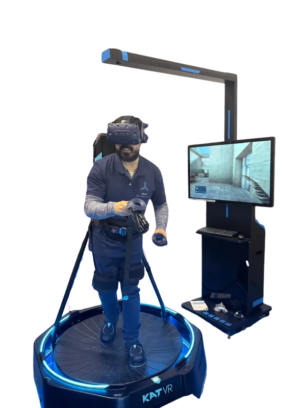 Operario con gafas de realidad virtual sobre una plataforma omnidireccional junto a la pantalla del instructor